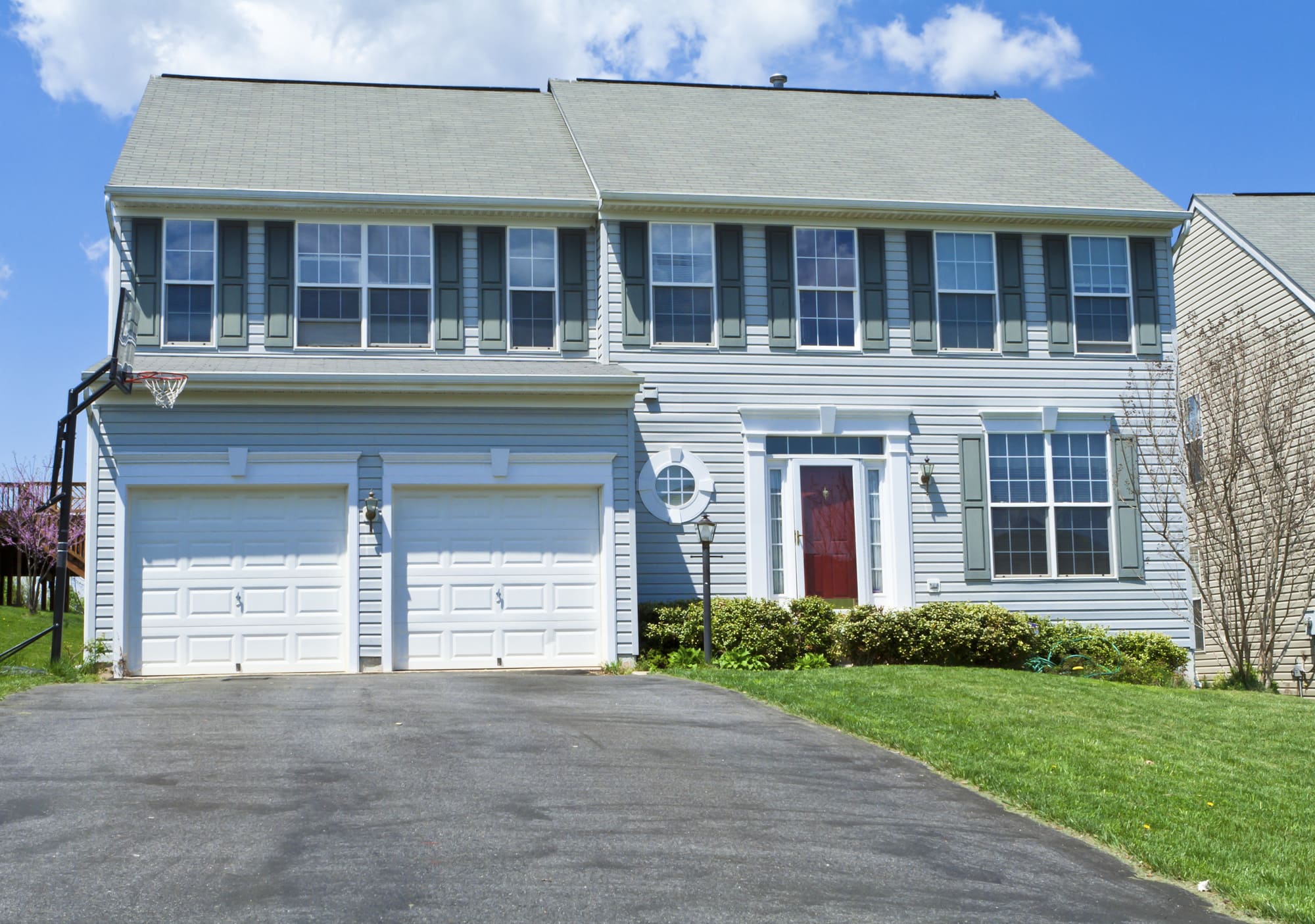 A two-story home featuring a garage and a spacious driveway, ideal for parking and outdoor activities.